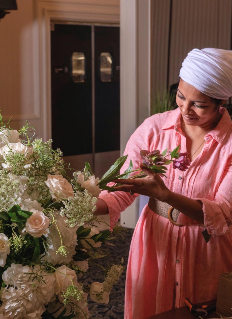 Juha Qureshi, the heart of Bridal Insignia, arranging fresh white roses as Metro Detroit's leading wedding decorator in Michigan, crafting a luxury floral centerpiece for Bridal Insignia