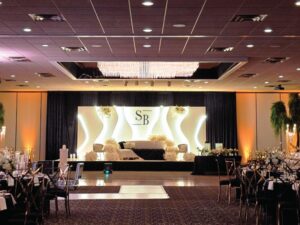 Modern, unique wedding stage décor in Michigan with waved structures and edge lighting, created by a leading wedding decorator in Michigan.