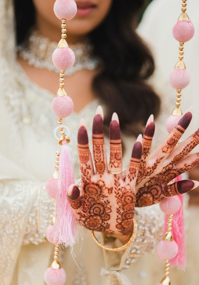Mehndi bride with decorative garland — pre-wedding celebration details by Bridal Insignia Events Metro Detroit