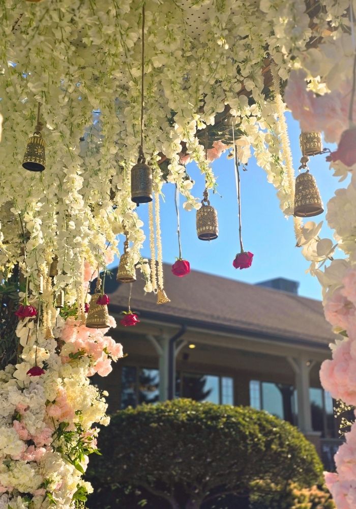 Mandap decorator in Metro Detroit — outdoor floral canopy with temple bells and wisteria by Bridal Insignia Events