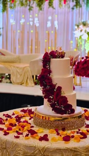 Elegant sweetheart table decor in Metro Detroit by Bridal Insignia — champagne sequin table cover with golden cake stand, floral wedding cake and red rose petals
