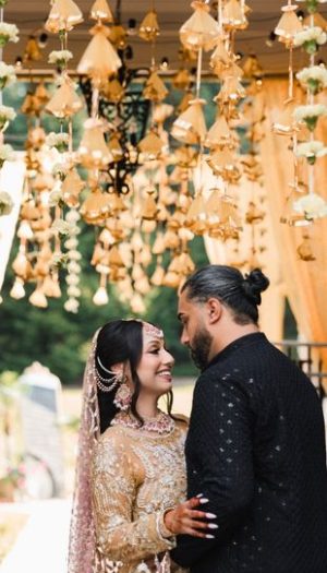 A couple celebrating their Mehndi surrounded by vibrant Sangeet and Mehndi decor in Metro Detroit by Bridal Insignia
