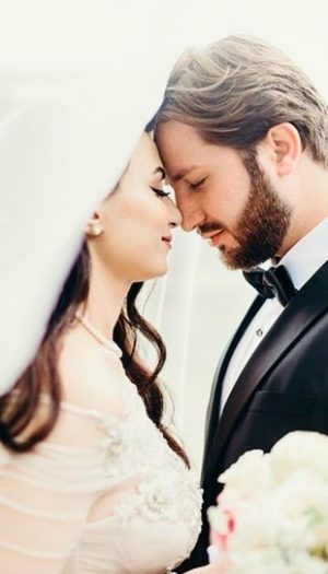 A couple sharing a romantic moment surrounded by elegant wedding ceremony decor in Metro Detroit by Bridal Insignia